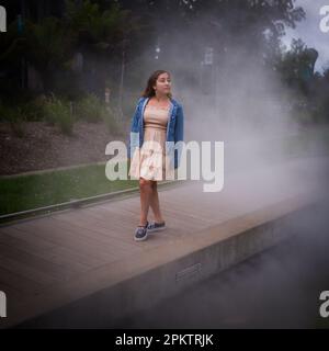 Randonnée asiatique pour les adolescents sur Misty Walkway | de Young Museum Gardens | Femme | Short Dress denim Jacket Banque D'Images