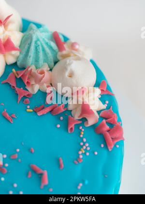 studio shot de chocolat bleu givré glaçage gâteau blanc de tasse, licorne, meringue et saupoudrer sur le dessus Banque D'Images