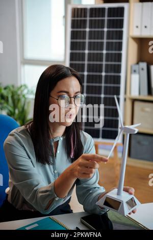 Ingénieur sérieux en énergie éolienne regardant le modèle de nouvelle éolienne Banque D'Images