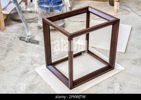 Cadre en bois de table de chevet en noyer massif dans l'atelier. Menuiserie joint angulaire de planches sur les chevilles Banque D'Images