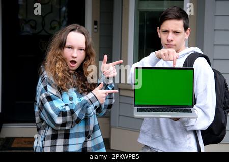 adolescent garçon adolescente fille dansant se réjouir montrant les doigts écran vert couleur clé sur l'ordinateur sur les épaules sac à dos école apprendre le rire sincère publicité en ligne apprentissage podcast sur la plate-forme Banque D'Images