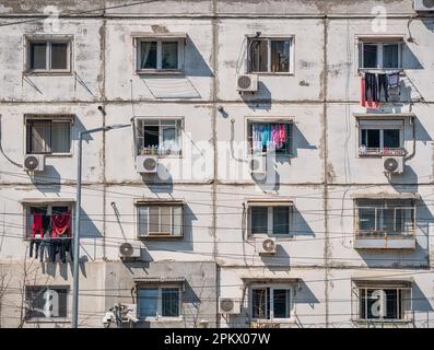 L'immeuble d'appartements de l'époque communiste était usé contre le ciel bleu de Bucarest en Roumanie. Laid ensemble de logements communistes traditionnels. Noir et blanc Banque D'Images