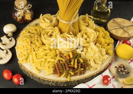 Assortiment de pâtes séchées, sur fond en bois. Mélange de pâtes différentes et crues, vue latérale. Placer pour le texte Banque D'Images