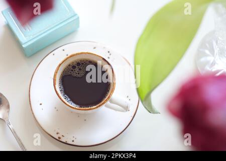 Une tasse de café noir est placée sur une table Banque D'Images