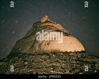 Formation de roche illuminée aux Pinnacles de Trona la nuit avec des étoiles. Banque D'Images