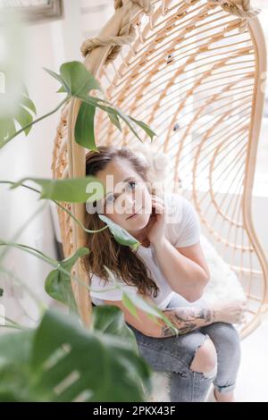 Portrait d'une belle femme réfléchie regardant à travers les plantes Banque D'Images
