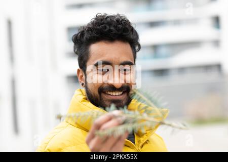 Jeune homme tenant un blanc vert dans la main à l'extérieur Banque D'Images