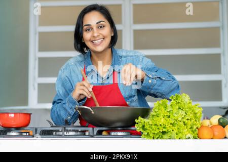 Femme latino-américaine mature préparant des plats végétariens dans la cuisine Banque D'Images