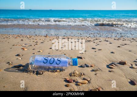 La contamination en plastique de la mer. Message SOS dans une bouteille en plastique au bord de la mer. Banque D'Images