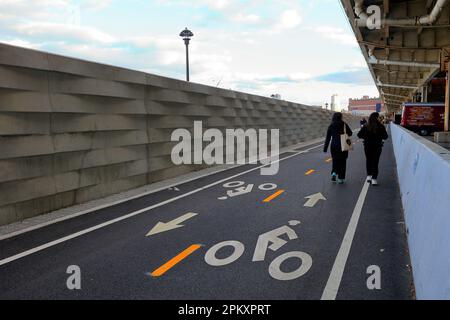 Les gens qui marchent le long d'une section de la voie verte de l'East River à Stuyvesant Cove avec des murs d'inondation de 8 pieds de haut qui séparent le .. (voir plus d'informations) Banque D'Images