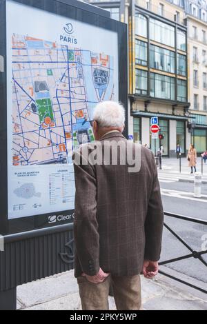 Homme âgé distingué en tenue élégante étudiant Paris Map dans les rues Banque D'Images