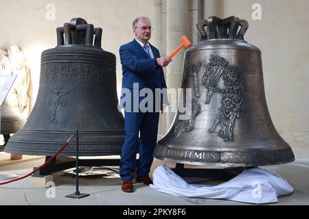 Magdebourg, Allemagne. 10th avril 2023. Reiner Haseloff (CDU), ministre-président de Saxe-Anhalt, frappe la première cloche 'Cantemus' lors d'un service festif pour marquer son inauguration. Cinq nouvelles cloches pour la sonnette de la cathédrale de Magdeburg ont été présentées et inaugurées le lundi de Pâques. Credit: Peter Gercke/dpa-Zentralbild/dpa/Alay Live News Banque D'Images