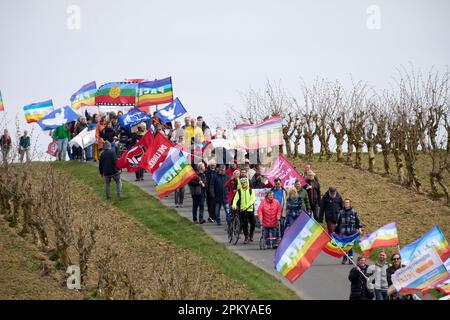 10 avril 2023, Rhénanie-Palatinat, Büchel : les participants à la marche de Pâques marchent à côté de la clôture de la base aérienne de la Bundeswehr. Toujours en 2023, sous l'impression de la guerre de la Russie contre l'Ukraine, de nombreuses marches de Pâques ont eu lieu dans toute l'Allemagne. Photo: Thomas Frey/dpa Banque D'Images