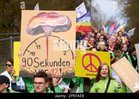 10 avril 2023, Rhénanie-Palatinat, Büchel : les participants à la marche de Pâques marchent à côté de la clôture de la base aérienne de la Bundeswehr. Toujours en 2023, sous l'impression de la guerre de la Russie contre l'Ukraine, de nombreuses marches de Pâques ont eu lieu dans toute l'Allemagne. Photo: Thomas Frey/dpa Banque D'Images