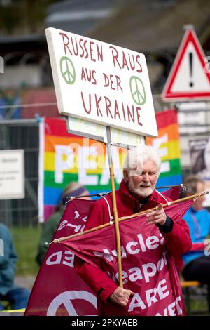 10 avril 2023, Rhénanie-Palatinat, Büchel : les participants à la marche de Pâques marchent à côté de la clôture de la base aérienne de la Bundeswehr. Toujours en 2023, sous l'impression de la guerre de la Russie contre l'Ukraine, de nombreuses marches de Pâques ont eu lieu dans toute l'Allemagne. Photo: Thomas Frey/dpa Banque D'Images