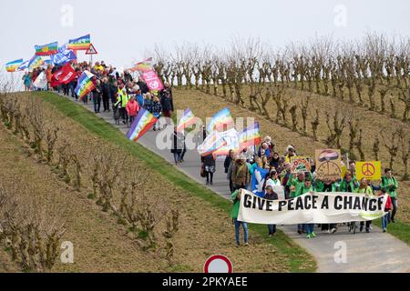 10 avril 2023, Rhénanie-Palatinat, Büchel : les participants à la marche de Pâques marchent à côté de la clôture de la base aérienne de la Bundeswehr. Toujours en 2023, sous l'impression de la guerre de la Russie contre l'Ukraine, de nombreuses marches de Pâques ont eu lieu dans toute l'Allemagne. Photo: Thomas Frey/dpa Banque D'Images