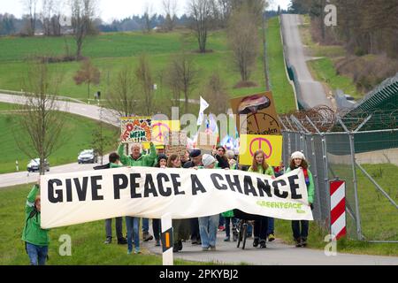 10 avril 2023, Rhénanie-Palatinat, Büchel : les participants à la marche de Pâques marchent à côté de la clôture de la base aérienne de Bundeswehr à Büchel. En 2023, de nombreuses marches de Pâques ont également eu lieu à travers l'Allemagne sous l'impression de la guerre de la Russie contre l'Ukraine. Photo: Thomas Frey/dpa Banque D'Images