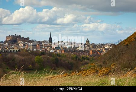 Holyrood Park, Édimbourg, Écosse, Royaume-Uni. 10 avril 2023. Nuageux après-midi lumineux avec une forte douche sur la ville dans l'après-midi, température autour de 13 degrés centigrades. Sur la photo : une vue depuis le parc Holyrood vers le centre-ville et le château d'Édimbourg. Banque D'Images