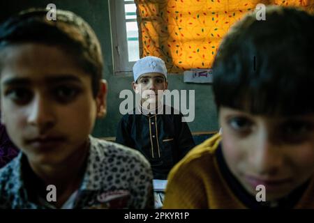 Srinagar, Inde. 09th avril 2023. Un garçon musulman cachemiri regarde tout en lisant le Saint Coran dans une école religieuse locale, ou école religieuse musulmane, pendant le mois Saint du Ramadan. Partout dans le monde, les musulmans marquent le mois du Ramadan, où les observants jeûnent de l'aube au crépuscule. Crédit : SOPA Images Limited/Alamy Live News Banque D'Images