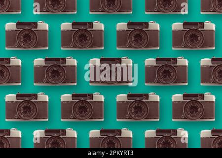Arrière-plan de divers appareils photo vintage disposés en rangées sur une surface bleue avec objectif Banque D'Images
