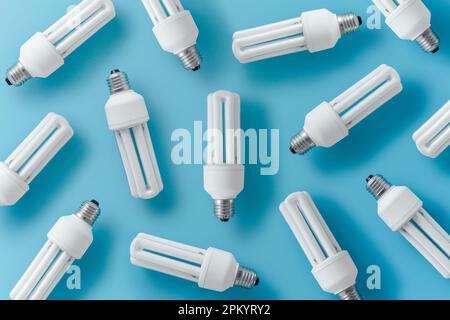 Jeu d'ampoules fluocompactes disposées sur fond bleu représentant le concept de diverses idées Banque D'Images