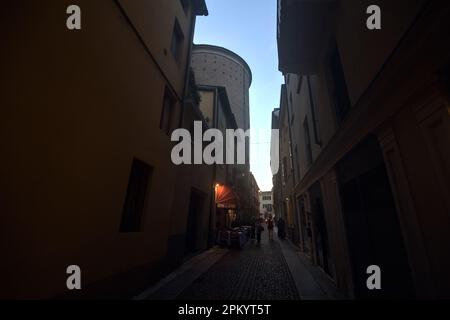 Ruelle pavée étroite entre de grands bâtiments dans une ville italienne au crépuscule Banque D'Images