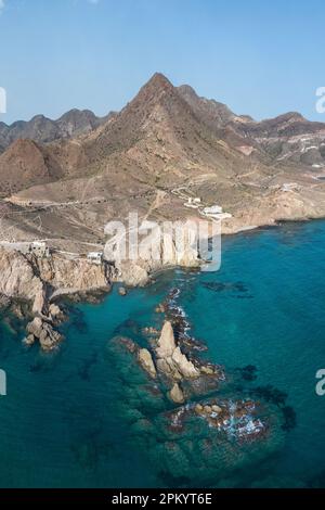 Vue de drone de formations rocheuses rugueuses situées près de la mer ondulée contre le ciel bleu à Almeria Banque D'Images
