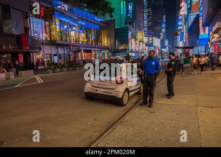 Vue des policiers près de la voiture de police sur Manhattan Street la nuit. New York, États-Unis. Banque D'Images