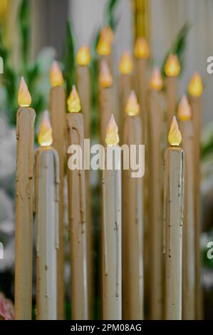 Photo verticale d'un groupe de bougies artificielles en plastique avec des ampoules simulant des flammes, la première étant dans un foyer sélectif Banque D'Images