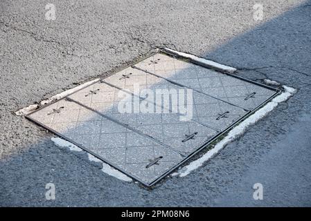 couvercle de trou d'homme en pierre sur asphalte Banque D'Images