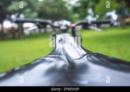 Bande d'un vélo au premier plan et vélo flou devant dans un carré, concept de cyclisme. Banque D'Images
