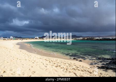 Sable blanc, eau bleue et nuages orageux sur la plage de la Concha, village des surfeurs d'El Cotillo, Fuerteventura, îles Canaries, Espagne Banque D'Images