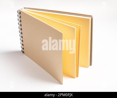 Papeterie pour artistes, livre d'esquisses ouvert avec pages de papier jaune pour le dessin. Banque D'Images