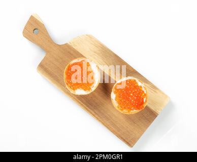 Deux tartelettes remplies de caviar de saumon rouge sur un plan de cuisine en bois, vue du dessus Banque D'Images