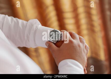 Homme d'affaires vérifie l'heure sur sa montre-bracelet Banque D'Images