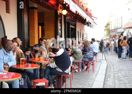 Paris, France, 29 octobre 2022 : une foule animée de touristes profite d'une chaude journée d'été dans un bar typique de Montmartre à Paris, France, France Banque D'Images