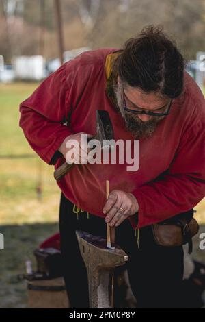 Kaiserslautern, Allemagne. 10th avril 2023. Forgeron médiéval qui s'entaille dans un clou en fer forgé lors d'une démonstration de fabrication. Credit: Gustav Zygmund/Alamy News Banque D'Images