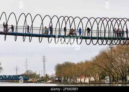 Oberhausen, NRW, le 10th avril 2023. Les randonneurs apprécient un lundi de Pâques plutôt ensoleillé et doux sur le célèbre pont 'linky Springs to Fame' d'Oberhausen. Le pont piétonnier, long de 406 mètres et traversant le canal Rhin-Herne, a été conçu par l'artiste Tobias Rehberger. Il est illuminé la nuit et aurait été inspiré par le jouet slinky. Credit: Imagetraceur/Alamy Live News Banque D'Images