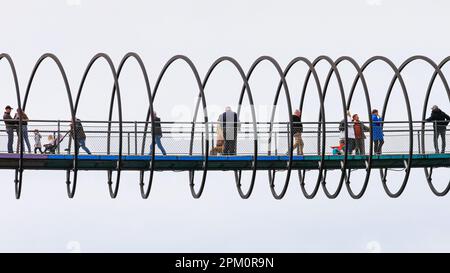 Oberhausen, NRW, le 10th avril 2023. Les randonneurs apprécient un lundi de Pâques plutôt ensoleillé et doux sur le célèbre pont 'linky Springs to Fame' d'Oberhausen. Le pont piétonnier, long de 406 mètres et traversant le canal Rhin-Herne, a été conçu par l'artiste Tobias Rehberger. Il est illuminé la nuit et aurait été inspiré par le jouet slinky. Credit: Imagetraceur/Alamy Live News Banque D'Images