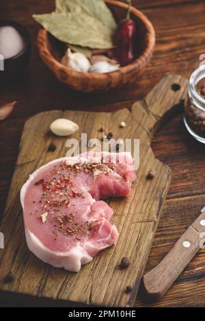 Steak de porc avec épices moulues on cutting board Banque D'Images