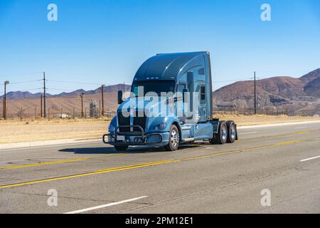 Victorville, CA, États-Unis – 25 mars 2023 : un camion semi-remorque à cabine conduit sur une route rurale à Victorville, Californie. Banque D'Images
