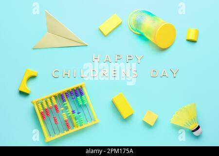 Envoyez DES SMS À HAPPY CHILDREN DAY avec des jouets sur fond bleu Banque D'Images