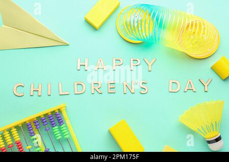 Envoyez DES SMS À HAPPY CHILDREN DAY avec des jouets sur fond vert Banque D'Images