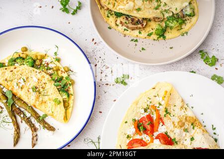 Omelettes savoureuses avec tomates, champignons et asperges sur fond clair Banque D'Images