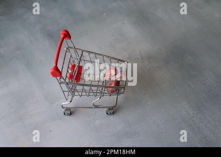 Image de mise au point sélective du modèle de rein humain à l'intérieur du chariot à provisions. Symbole de transplantation d'organe. le marché illégal des organes, recevant l'organe donneur, Banque D'Images