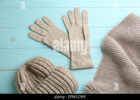 Gants, écharpe et chapeau élégants sur fond en bois bleu clair, pose à plat Banque D'Images