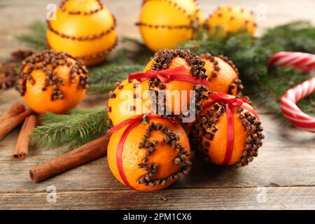 Boulettes de pommes de terre faites de mandarines fraîches avec clous de girofle sur une table en bois. Ambiance de Noël Banque D'Images