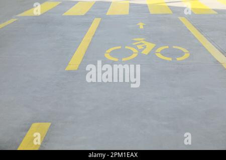 Piste cyclable avec panneau vélo jaune peint et flèche près du passage pour piétons Banque D'Images