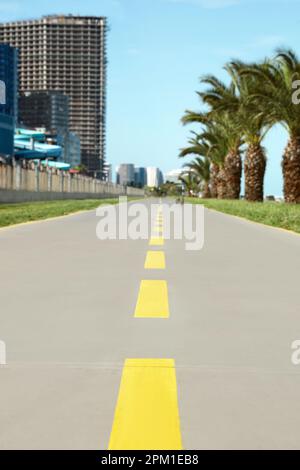 Piste cyclable avec lignes de séparation jaunes peintes sur l'asphalte, gros plan Banque D'Images