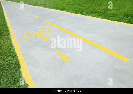 Piste cyclable avec panneau jaune peint et flèche Banque D'Images